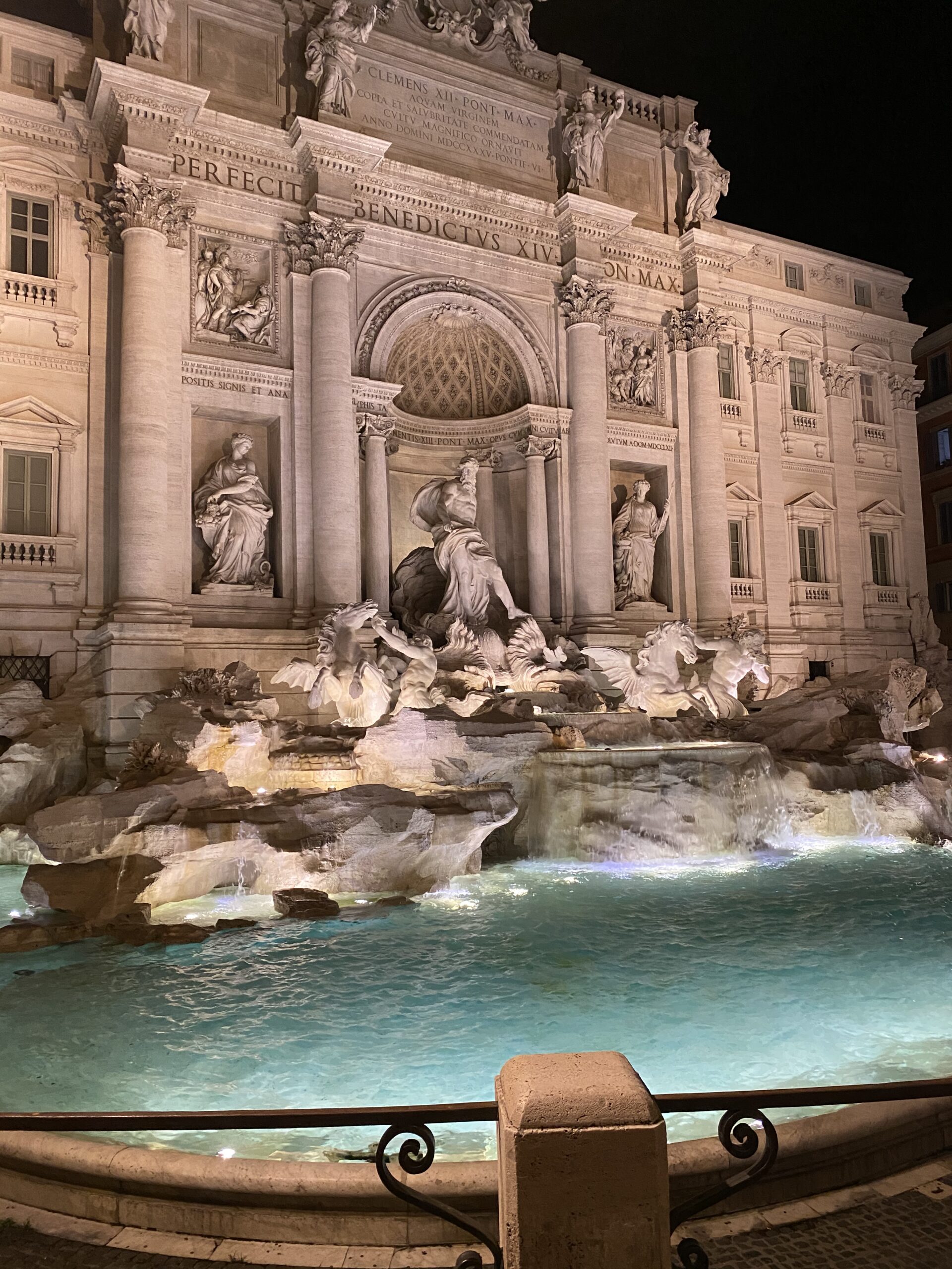 Trevi Fountain lit up at night with an empty square